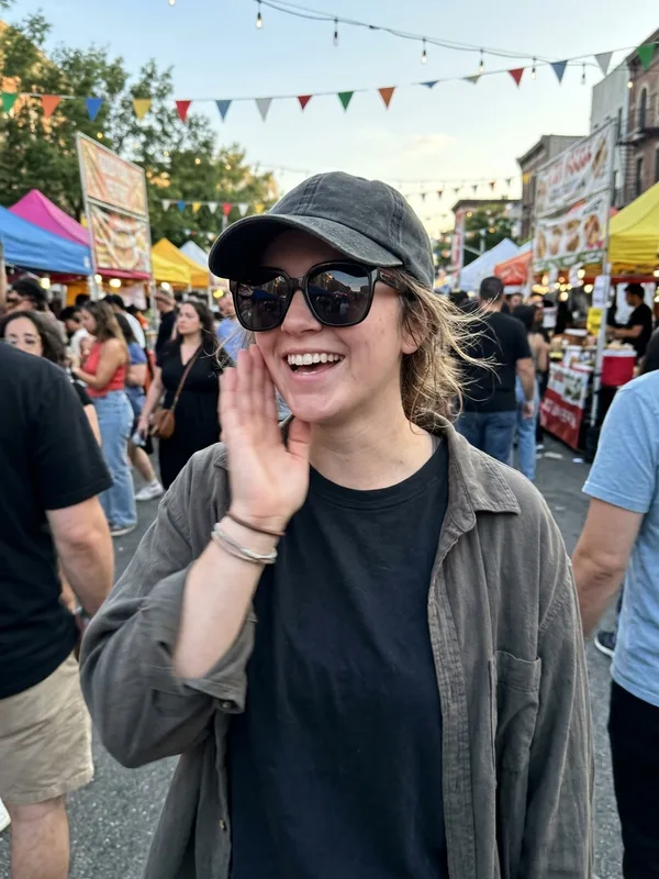 Bad example: woman wearing sunglasses and a cap with a hand by her face